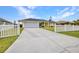 A long drive leads to the house with an attached 2 car garage, pristine lawn, and tropical landscaping at 474 Lomond Dr, Port Charlotte, FL 33953
