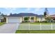 Lovely single-Gathering home with a well-maintained lawn, mature landscaping, and a charming white picket fence at 474 Lomond Dr, Port Charlotte, FL 33953