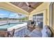 Inviting lanai with ceiling fan and summer kitchen opens to the refreshing waterfront pool area at 474 Lomond Dr, Port Charlotte, FL 33953