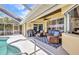 Covered lanai with waterfront views leads to a relaxing pool and patio area at 474 Lomond Dr, Port Charlotte, FL 33953