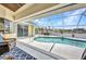Waterfront screened in lanai with pool, summer kitchen and relaxing seating area at 474 Lomond Dr, Port Charlotte, FL 33953