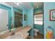Light blue bathroom features a large mirror, walk-in shower, and window for natural light at 543 Mayview Nw Ave, Port Charlotte, FL 33952