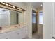 Bathroom with a white vanity, mirrored wall, a step-in shower with glass door, and a window for natural light at 543 Mayview Nw Ave, Port Charlotte, FL 33952
