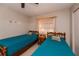 This bedroom features twin beds with wood frames, a ceiling fan, and a window providing plenty of natural light at 543 Mayview Nw Ave, Port Charlotte, FL 33952