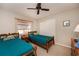 Cozy bedroom featuring twin beds with wooden frames, a window, and a ceiling fan for a comfortable stay at 543 Mayview Nw Ave, Port Charlotte, FL 33952