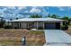 Charming single-story home featuring a metal roof, stone accents, and a convenient attached garage at 543 Mayview Nw Ave, Port Charlotte, FL 33952