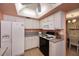 Bright kitchen with white cabinets and appliances near the dining room at 543 Mayview Nw Ave, Port Charlotte, FL 33952