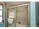 This shower features neutral tile with a sliding glass door and a large window for natural light at 543 Mayview Nw Ave, Port Charlotte, FL 33952