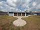 The backyard of the home with a walkway to the garage, featuring landscaping at 635 W Tarpon Nw Blvd, Port Charlotte, FL 33952