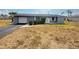 A well-maintained single-story house with a garage, tidy yard, and an inviting front door at 635 W Tarpon Nw Blvd, Port Charlotte, FL 33952