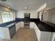 Modern kitchen features white cabinets, black countertops, stainless steel appliances and breakfast bar at 635 W Tarpon Nw Blvd, Port Charlotte, FL 33952