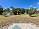 Expansive backyard with mature trees, lush lawn, and a storage shed at 700 Dolphin Pkwy, Punta Gorda, FL 33950