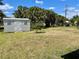 Backyard shed with lush green grass and many trees providing lots of shade at 700 Dolphin Pkwy, Punta Gorda, FL 33950