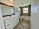 Bathroom featuring large vanity and mirror, toilet, and tub with tiled wall surround at 700 Dolphin Pkwy, Punta Gorda, FL 33950