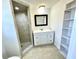 Bathroom featuring updated single vanity, framed mirror, and tiled walk-in shower at 700 Dolphin Pkwy, Punta Gorda, FL 33950