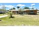 Charming single-story home with a well-manicured lawn, complemented by mature trees, offering a welcoming curb appeal at 700 Dolphin Pkwy, Punta Gorda, FL 33950