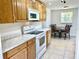 Kitchen featuring wooden cabinets, stone countertops, and white appliances at 700 Dolphin Pkwy, Punta Gorda, FL 33950