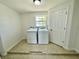 Laundry room with tiled floor and new washer and dryer units next to window and exterior door at 700 Dolphin Pkwy, Punta Gorda, FL 33950