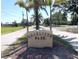 Welcome to Charlotte Park: A beautifully landscaped entrance sign amidst a tranquil, tree-lined street on a sunny day at 700 Dolphin Pkwy, Punta Gorda, FL 33950
