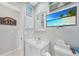 Bright bathroom featuring a vanity, mirror, and beach-themed decor for a relaxing coastal ambiance at 7333 Watson Ln, Port Charlotte, FL 33981