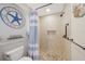 Stylish bathroom featuring granite counters, dark wood cabinetry, walk-in shower with tile surround, and coastal decor at 7333 Watson Ln, Port Charlotte, FL 33981