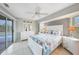 Relaxing bedroom with ceiling fan, coastal-themed bedding, ensuite bathroom and sliding door access to pool area at 7333 Watson Ln, Port Charlotte, FL 33981