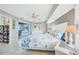 Comfortable bedroom with coastal-themed bedding, ceiling fan, ensuite bathroom and sliding door access to pool area at 7333 Watson Ln, Port Charlotte, FL 33981