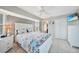 Comfortable bedroom with coastal-themed bedding, ceiling fan, ensuite bathroom and a mounted flatscreen TV at 7333 Watson Ln, Port Charlotte, FL 33981