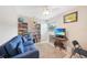 Cozy bedroom with a comfortable blue sofa, a TV, and bookshelves for relaxation and entertainment at 7333 Watson Ln, Port Charlotte, FL 33981