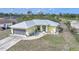 Charming exterior with a metal roof, swing, landscaped yard, and attached garage at 7333 Watson Ln, Port Charlotte, FL 33981