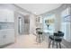 Bright eat-in kitchen featuring white cabinetry, tile flooring, a glass-top table and charming coastal decor at 7333 Watson Ln, Port Charlotte, FL 33981
