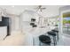 Bright kitchen with white cabinetry, stainless steel appliances, marble countertops and an island with stools at 7333 Watson Ln, Port Charlotte, FL 33981