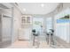 Bright kitchen nook featuring a glass table, white cabinets, and decorative beach-themed accents at 7333 Watson Ln, Port Charlotte, FL 33981
