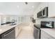Modern kitchen featuring stainless steel appliances, white cabinetry and an island with a breakfast bar at 7333 Watson Ln, Port Charlotte, FL 33981