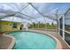 In-ground pool with screen enclosure offering a private outdoor swimming experience and an outbuilding at 7333 Watson Ln, Port Charlotte, FL 33981