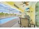 Relaxing pool patio with a TV, table, chairs and a view of the inviting pool at 7333 Watson Ln, Port Charlotte, FL 33981