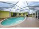 Beautiful in-ground pool surrounded by a screened enclosure and a patio area at 7333 Watson Ln, Port Charlotte, FL 33981