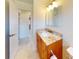 Bathroom featuring granite counters, wooden cabinetry, and tiled flooring at 745 Monaco Dr, Punta Gorda, FL 33950