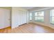 Bedroom featuring wood-look flooring, bay window, closet, and ample sunlight at 745 Monaco Dr, Punta Gorda, FL 33950