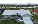 Charming one-story home featuring a well-manicured lawn, mature palm trees and a white tile roof at 745 Monaco Dr, Punta Gorda, FL 33950