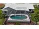 Aerial view of a private screened-in pool area, surrounded by lush landscaping and a brick trimmed pool at 745 Monaco Dr, Punta Gorda, FL 33950