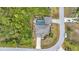 Aerial view of the home surrounded by mature trees, lush landscaping, and private pool at 9239 Impala Cir, Port Charlotte, FL 33981