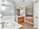 Bright bathroom with a glass shower, soaking tub, double sink vanity, and tile flooring at 9239 Impala Cir, Port Charlotte, FL 33981