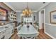 Bright dining room with a chandelier, hardwood floors, and a view into the living room at 9239 Impala Cir, Port Charlotte, FL 33981