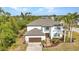 Two-story home exterior with a well-manicured lawn, a fountain, and mature palm trees at 9239 Impala Cir, Port Charlotte, FL 33981