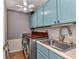 Bright laundry room with front load washer and dryer, utility sink, and blue cabinets at 9239 Impala Cir, Port Charlotte, FL 33981