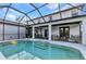 Screened pool with steps into pool, covered seating area, and lush landscaping create an inviting outdoor living space at 9239 Impala Cir, Port Charlotte, FL 33981