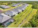 Aerial view of homes with screened-in pools in a neatly planned community with trees at 10995 Pinot Dr, Venice, FL 34293