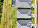 Birds-eye view of several grey-roofed homes with green lawns and one screened-in pool at 10995 Pinot Dr, Venice, FL 34293