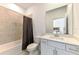Neutral bathroom with a tub and shower, a dark shower curtain, toilet and a single-sink vanity with a mirror at 10995 Pinot Dr, Venice, FL 34293
